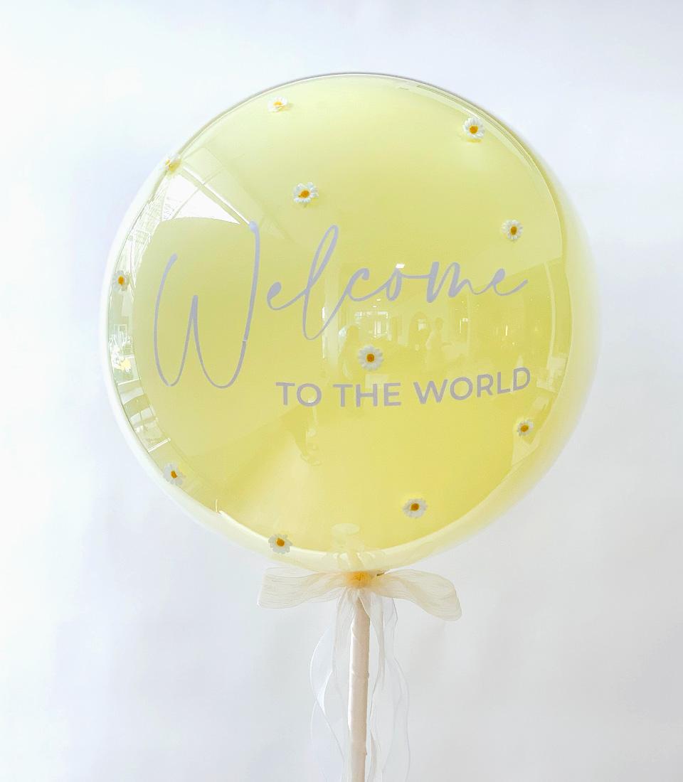 Cream ribbon-tied balloon bouquet with yellow fill and white daisy flowers, welcome baby gift