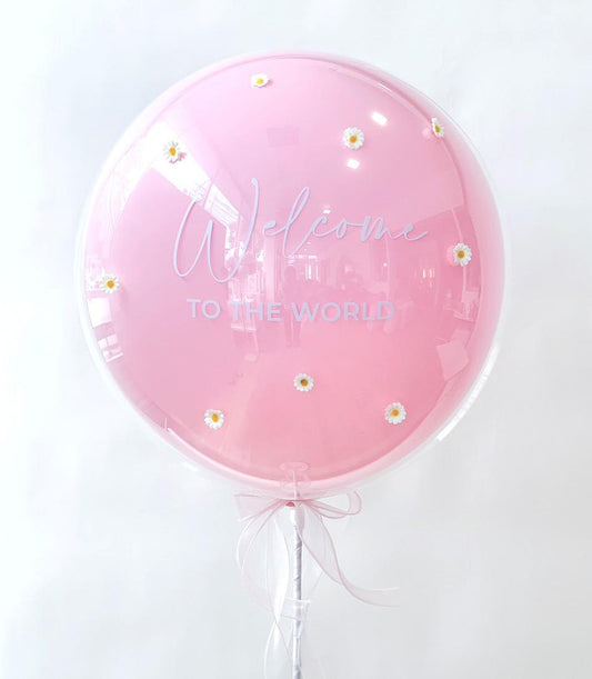 Pink welcome baby bubble balloon with daisy flowers and white ribbon bow