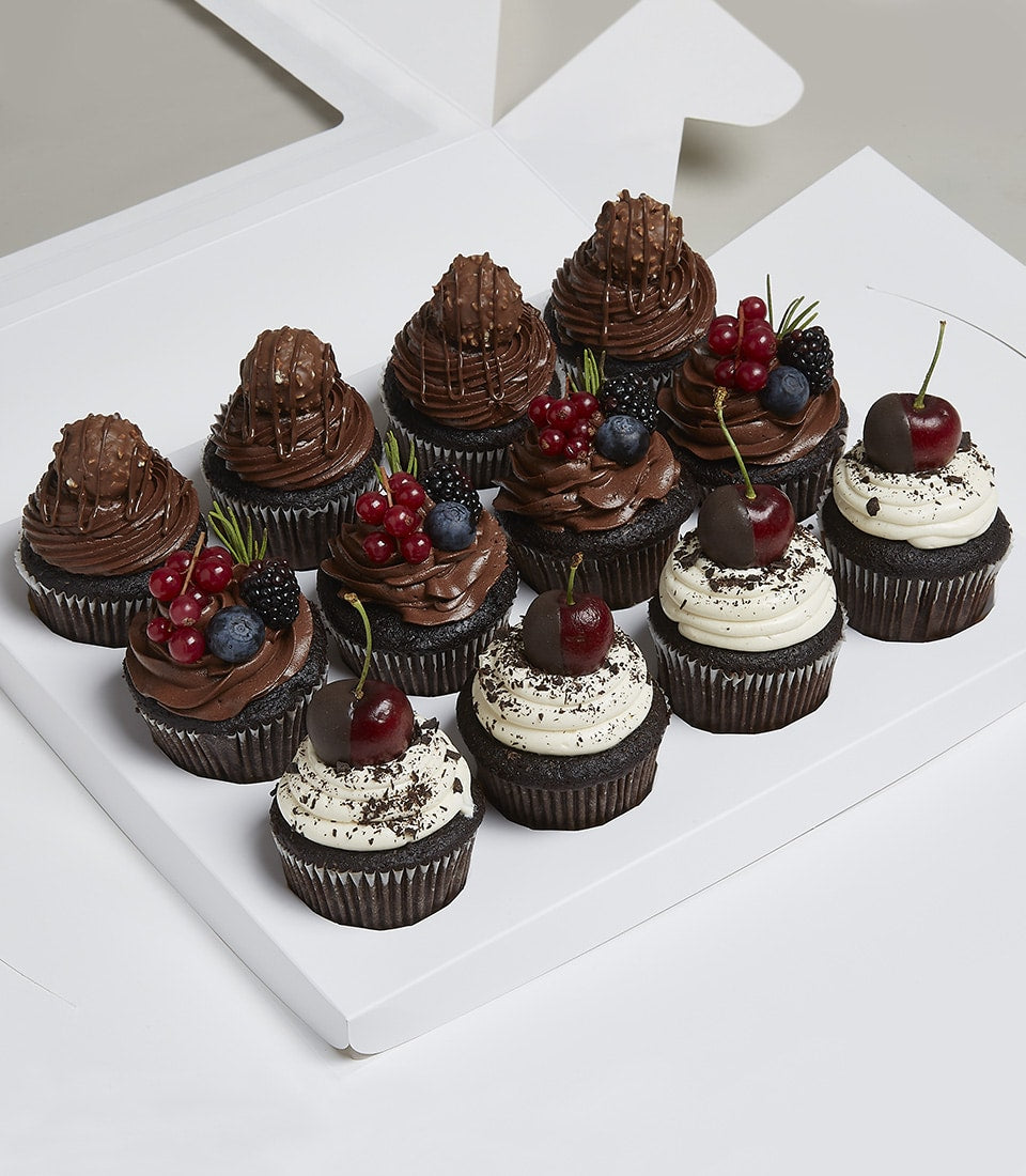 Charlotte Bakery artisan cupcakes in a box. British-style dark chocolate buttercream frosting, topped with fresh berries and chocolate-dipped cherries. Order custom cake Bangkok.