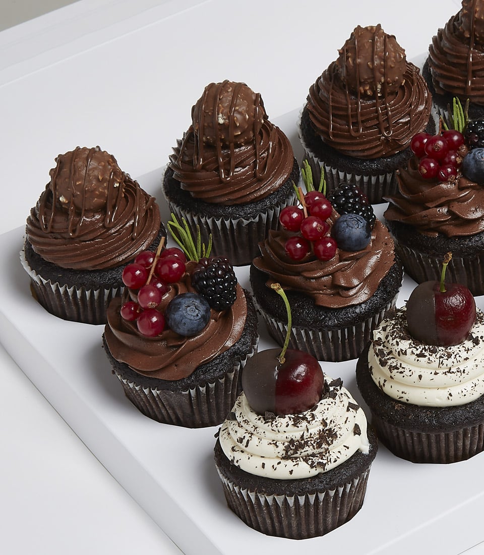 Charlotte Bakery artisan cupcakes: dark chocolate cakes with swirls of chocolate buttercream, topped with fresh berries and chocolate candies. Order custom cake Bangkok delivery.