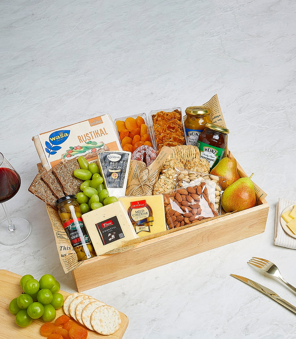 Artisan cheese and gourmet hamper with Emmental, Cheddar, Brie, crackers, olives, and preserves in wooden crate