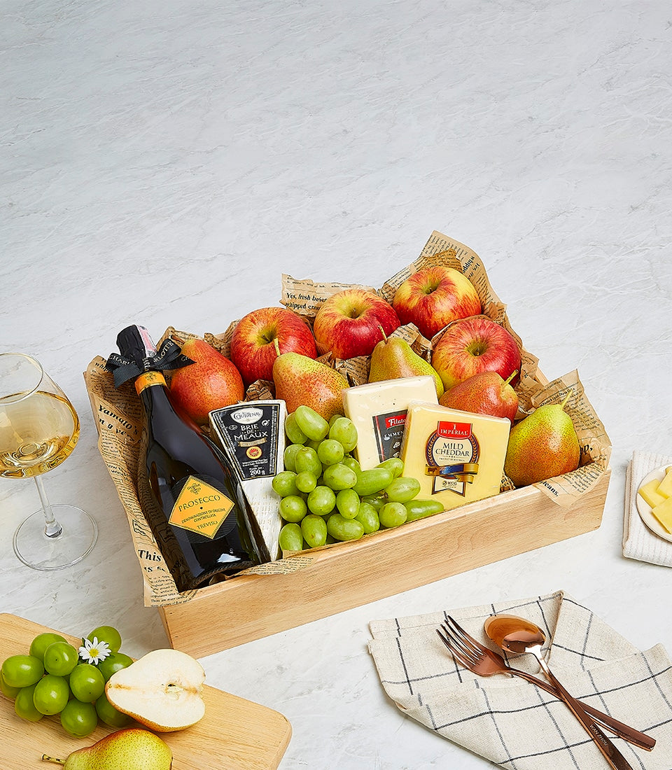 Wooden hamper with fresh fruit, artisan cheeses, and Prosecco for premium gifting