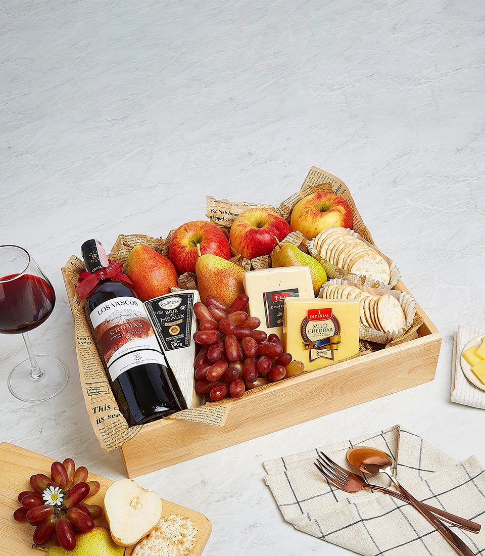 Premium red wine gift basket with Emmentaler cheese, Brie, crackers, fresh fruit, and wooden crate presentation