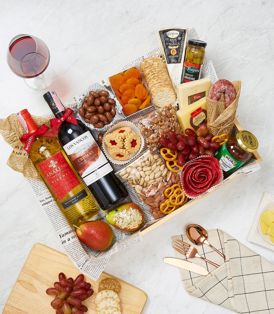Premium wine and gourmet gift hamper with red and white wines, artisan cheeses, charcuterie, nuts, and gourmet accompaniments