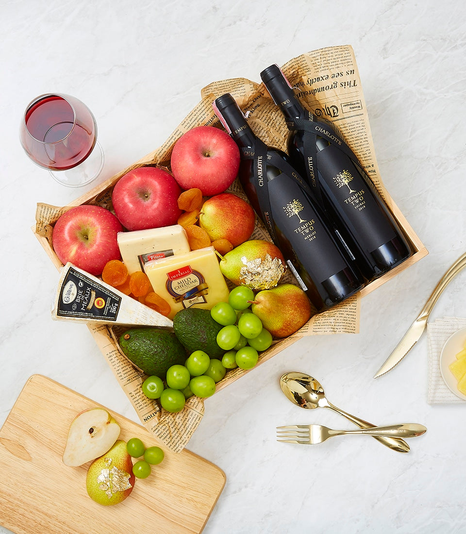 Premium wine and gourmet cheese gift basket with red wines, artisan cheeses, fresh fruits, and charcuterie