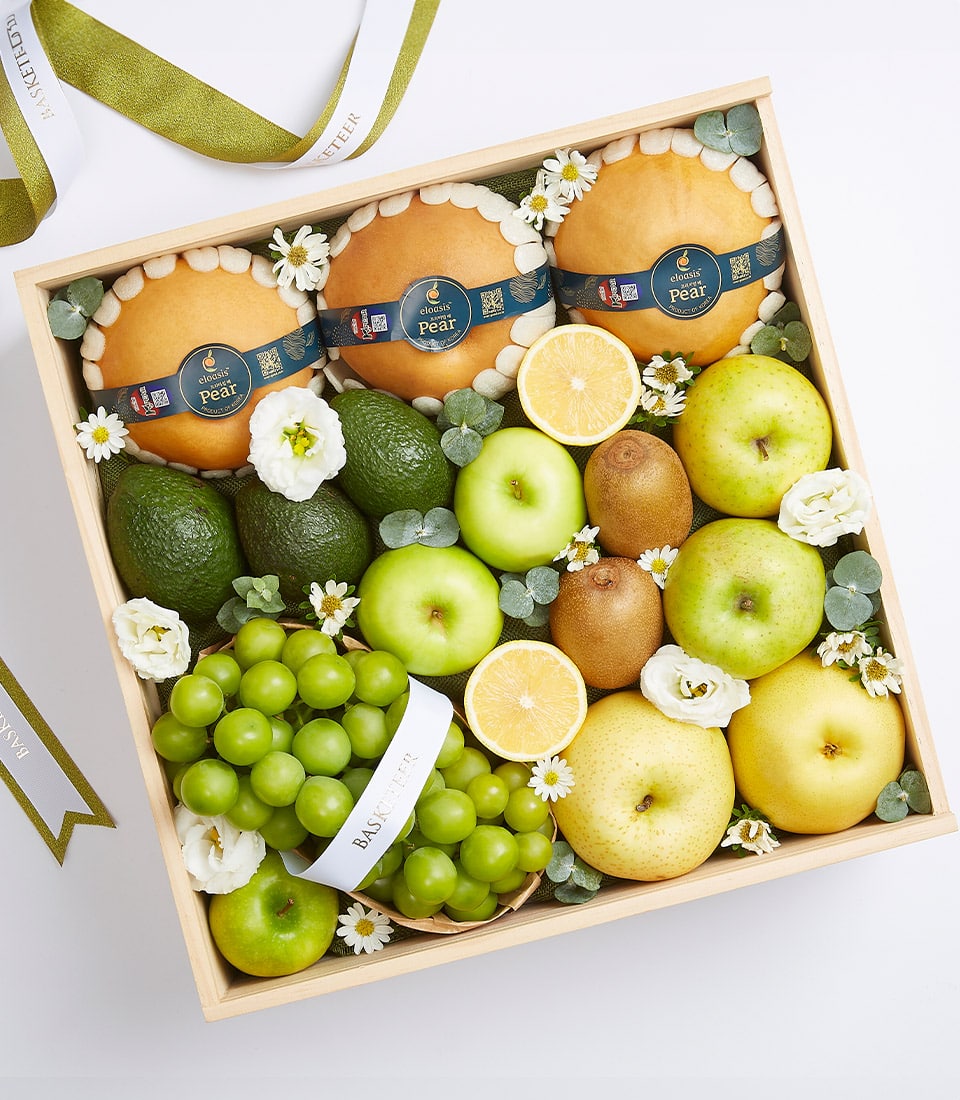 Premium fresh fruit crate with pears, avocados, green apples, kiwis, grapes, and lemon slices in wooden gift box