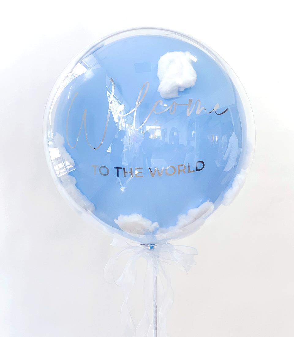 Light blue cloud balloon with "Welcome to the World" silver text and white ribbon for new baby gifts
