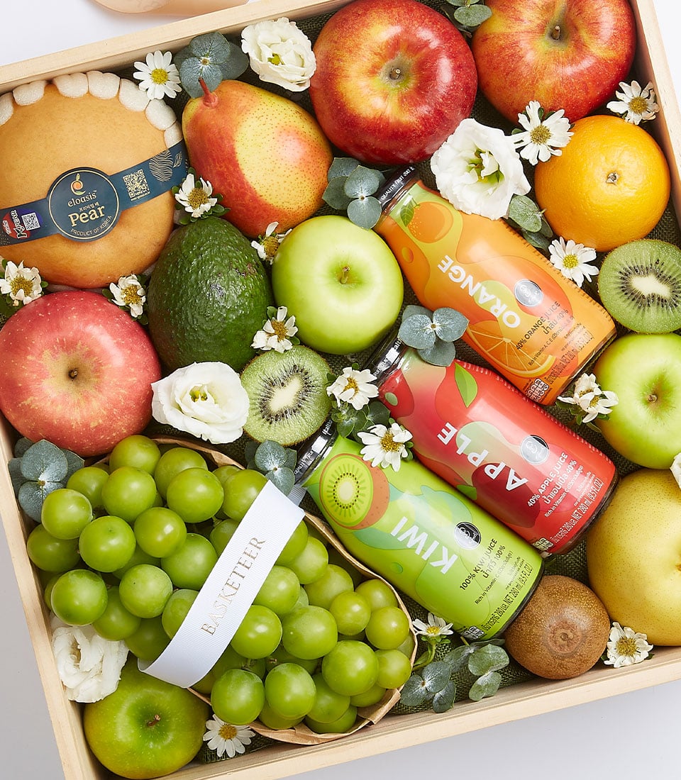 Premium fruit gift box with pears, apples, grapes, and fresh-pressed juices in wooden crate