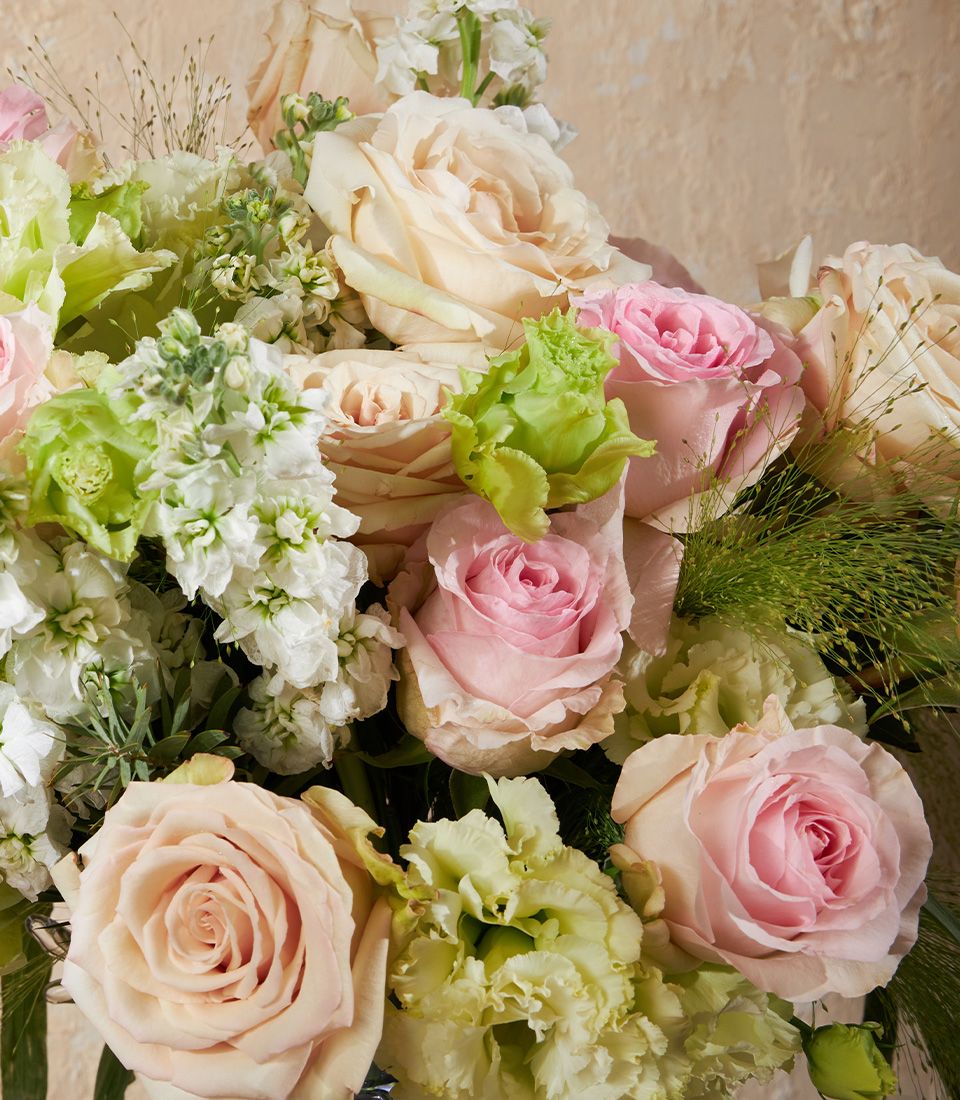 Blush and cream rose vase arrangement with soft pink blooms and green foliage for elegant gifting