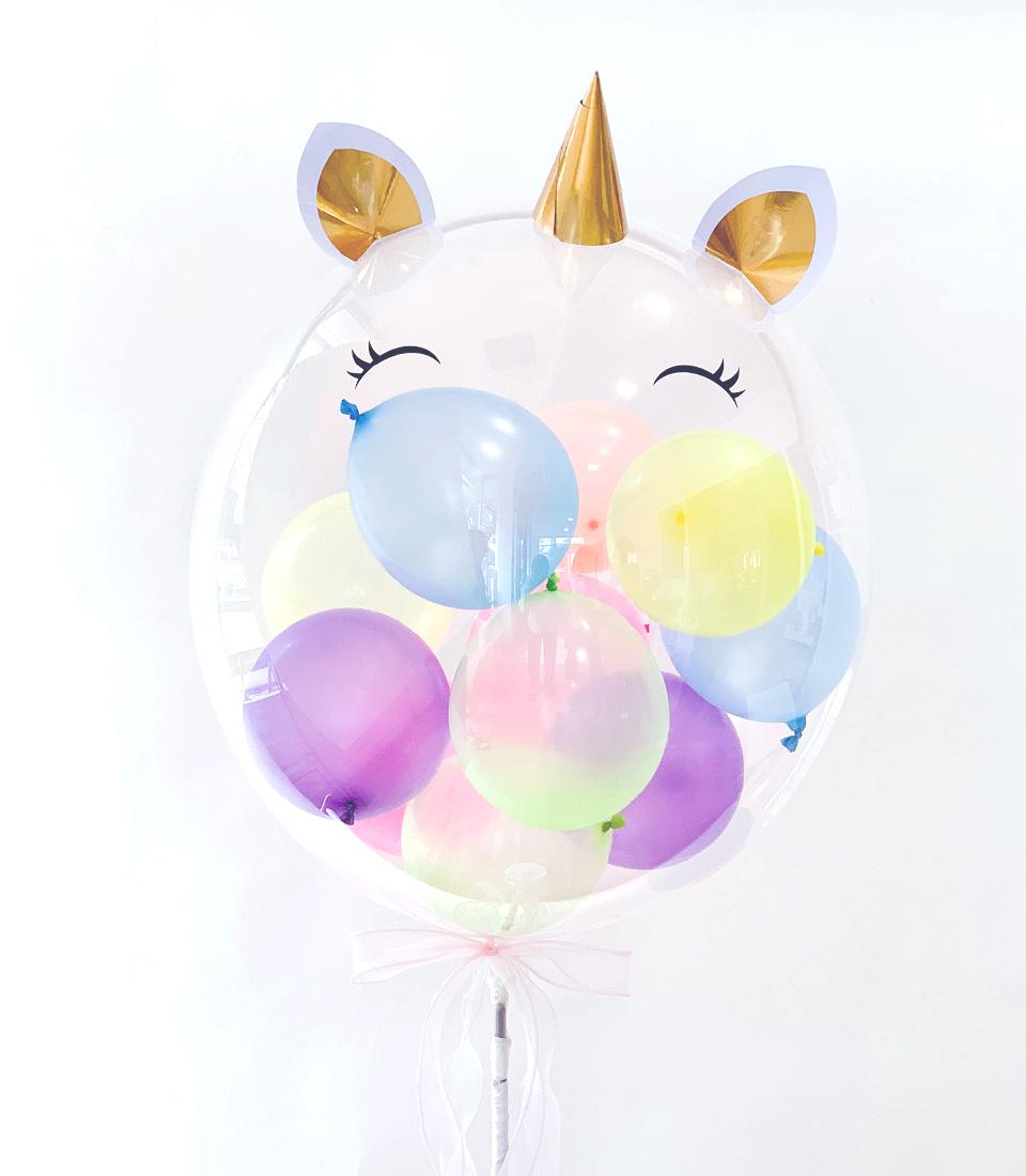 Unicorn Dream clear balloon with golden horn and ears, filled with pastel mini balloons, pink ribbon bow