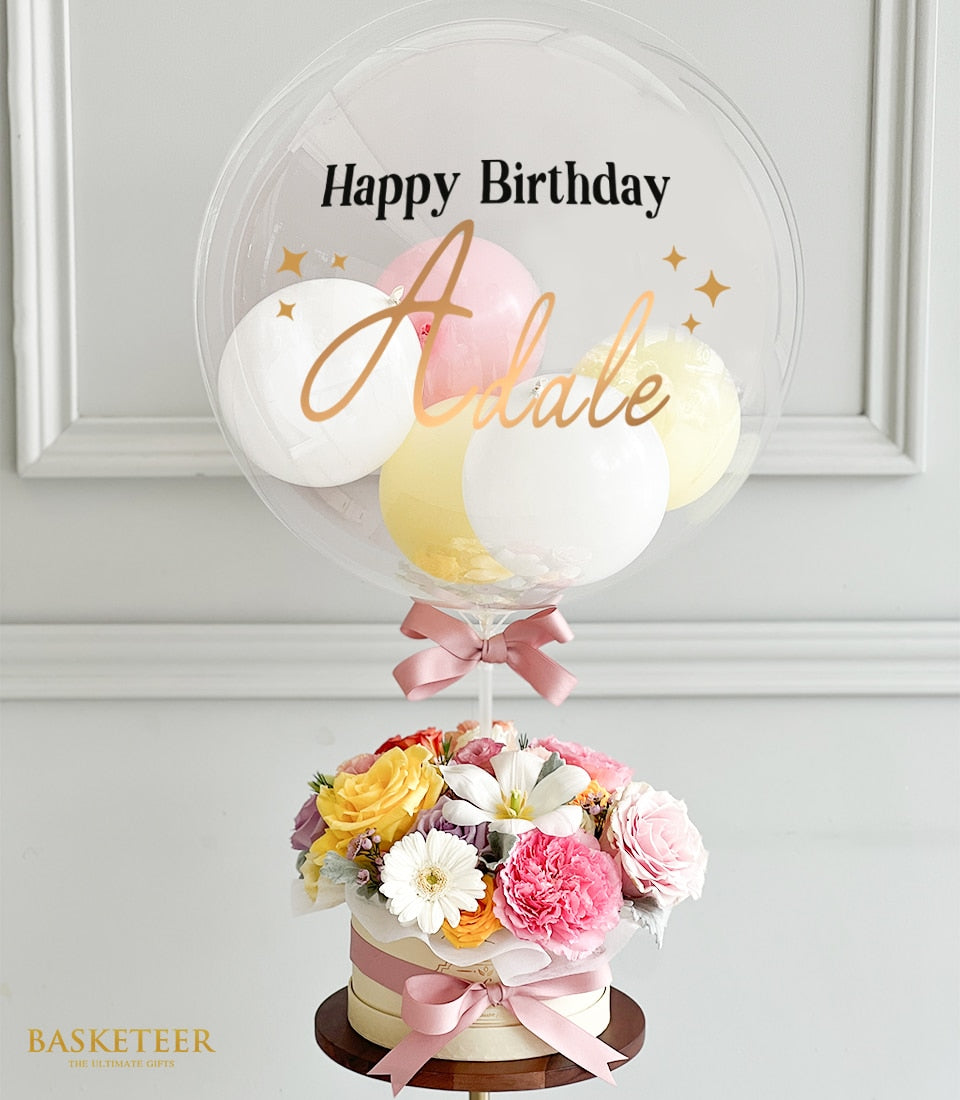 Personalized birthday bubble balloon arrangement with fresh roses, carnations, and daisies in pink, yellow, and white