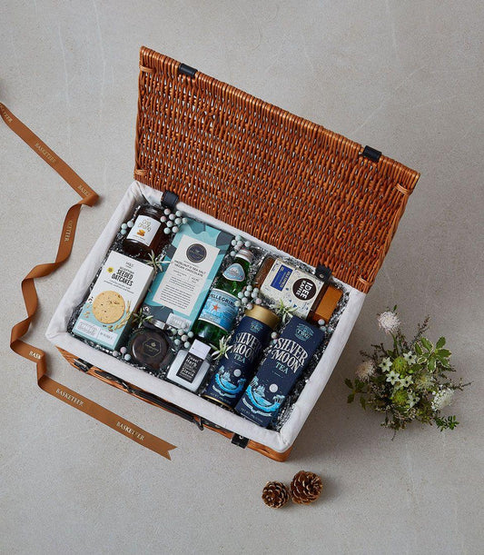 Brown wicker hamper with Silver Moon tea, Scottish oatcakes, vegan chocolate, and gourmet provisions
