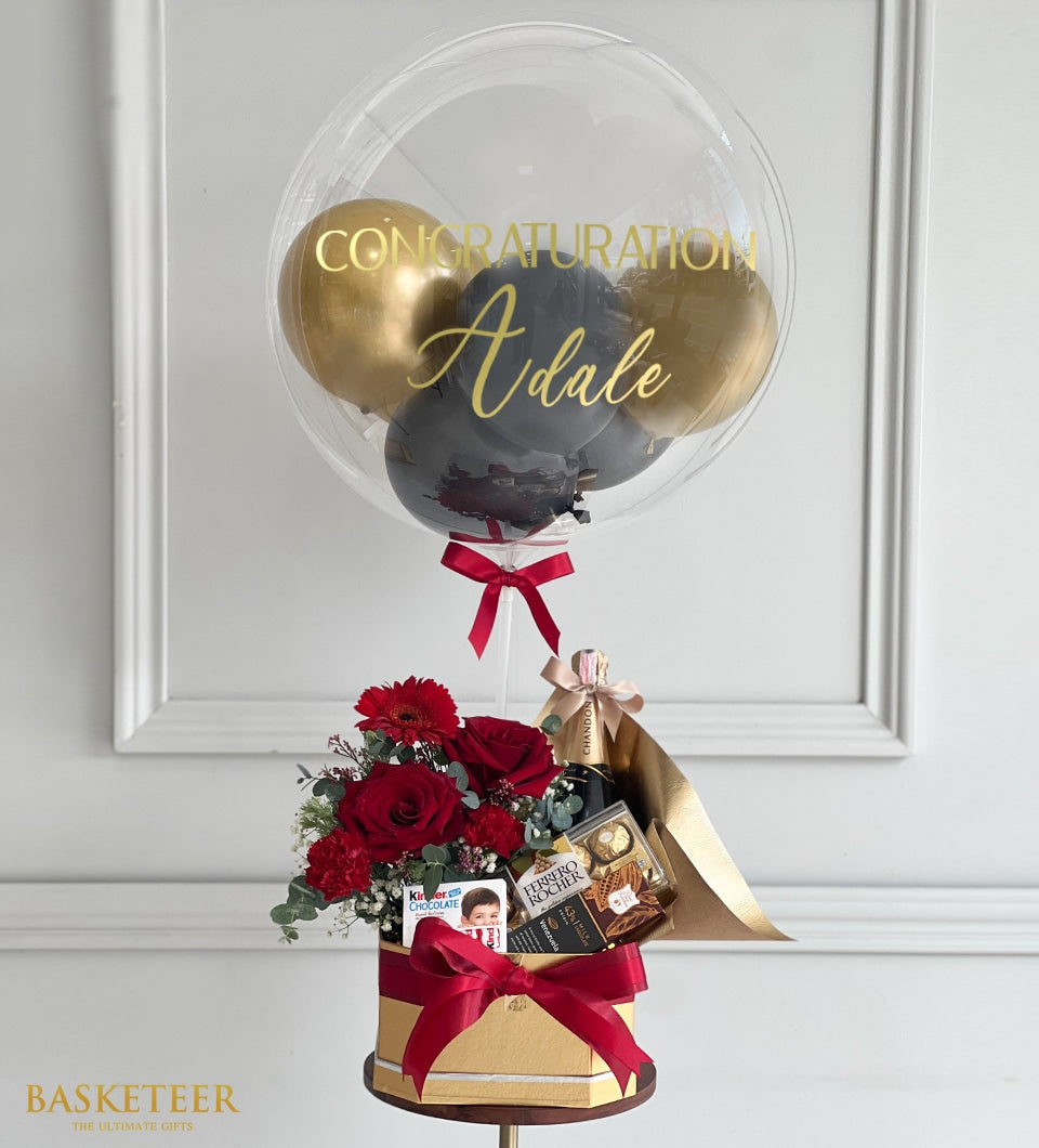 Luxury champagne congratulations gift set with personalized balloon, red roses, and gourmet chocolates in gold hexagonal box