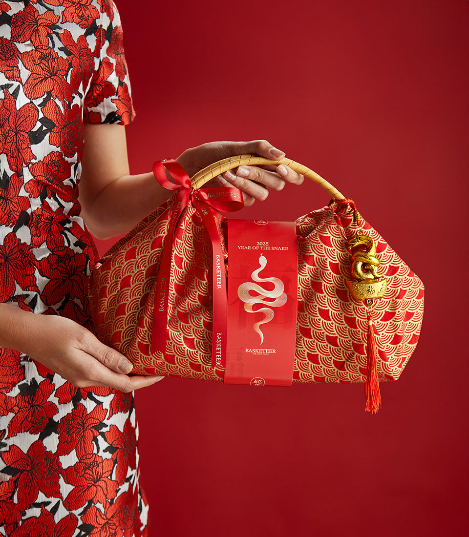 Red luxury mandarin gift bag with gold snake charm and zodiac tag for Chinese New Year