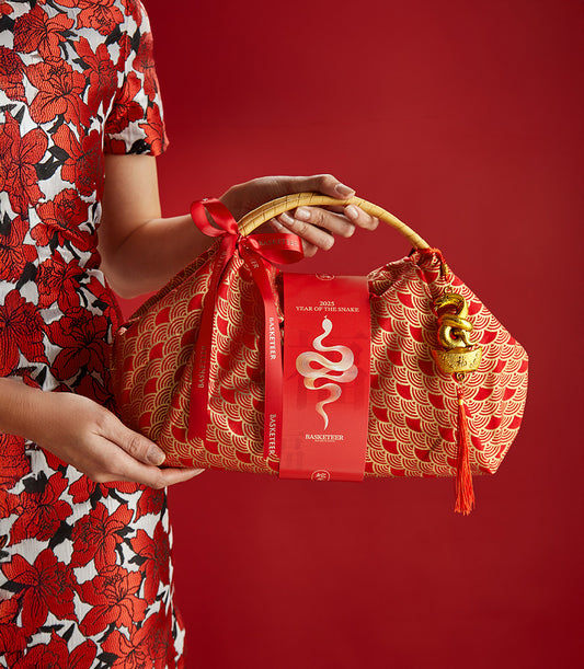 Red luxury mandarin gift bag with gold snake charm and zodiac tag for Chinese New Year