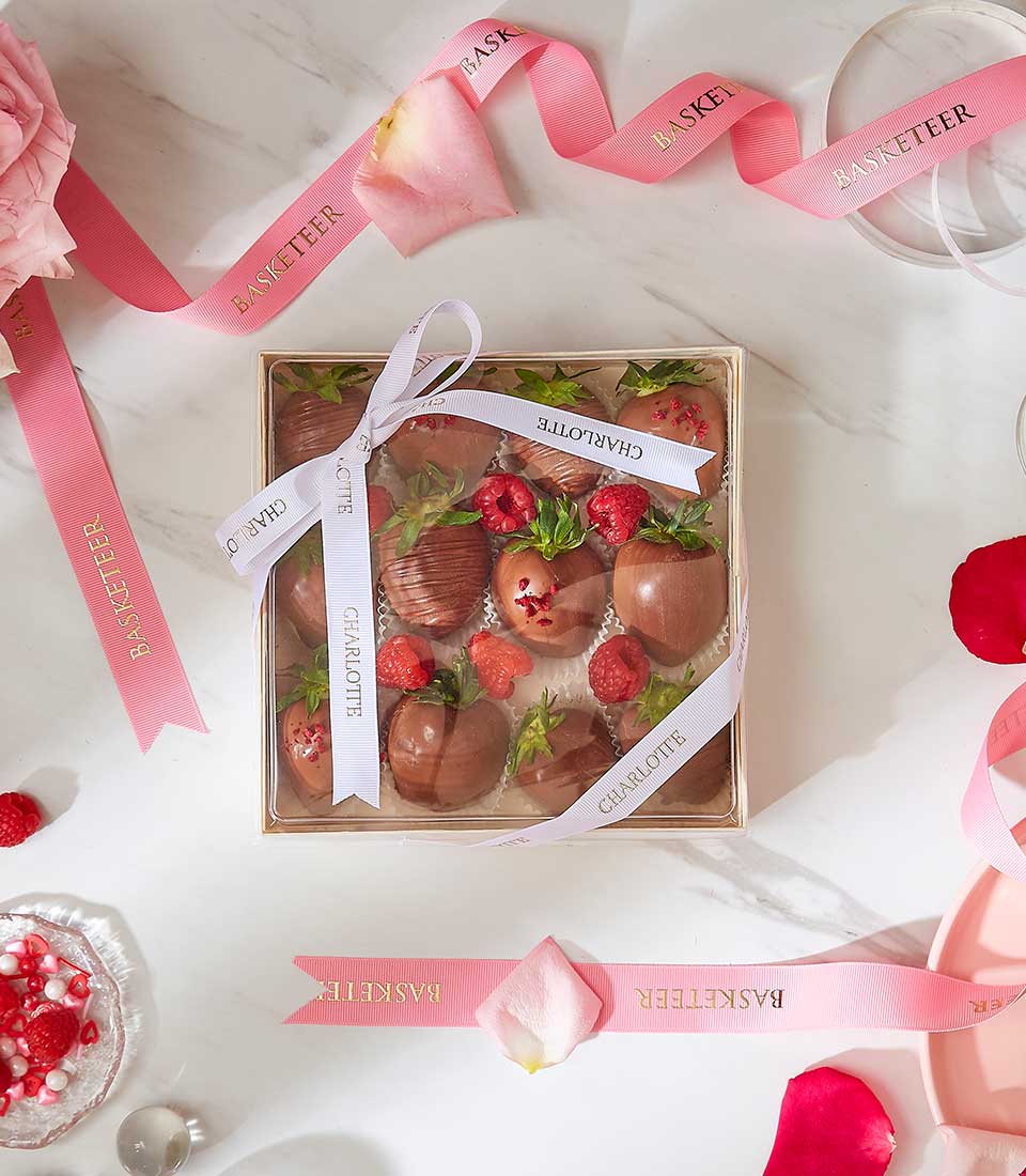 Luxury chocolate-covered strawberries gift box with fresh raspberries, tied with white ribbon for Valentine's Day