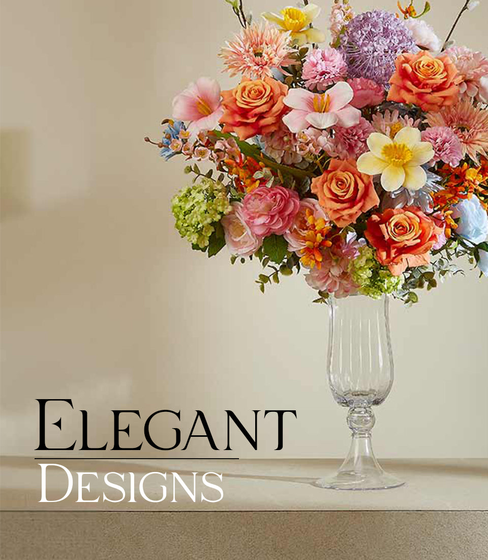 Vibrant summer artificial flower arrangement with orange roses, pink lilies, yellow daffodils, and purple alliums in fluted