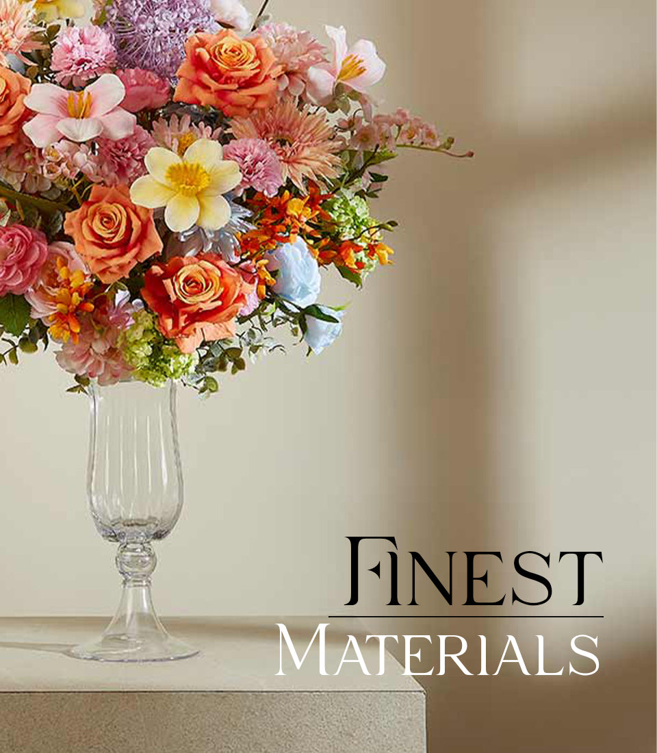 Vibrant mixed artificial flower arrangement with orange roses, pink carnations, and yellow daffodils in fluted glass vase