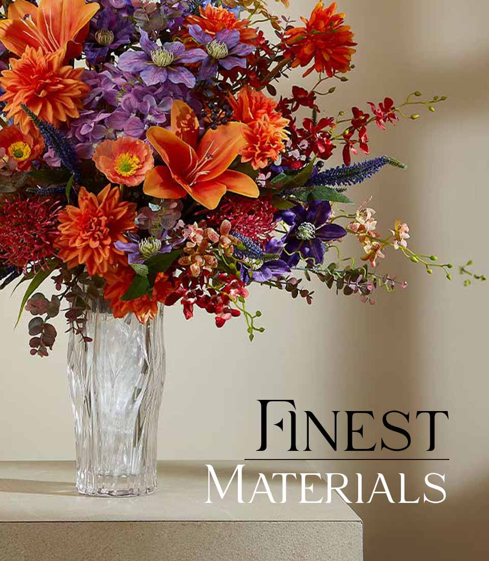 Vibrant orange lilies, purple clematis, and red dahlias in textured glass vase for gifting