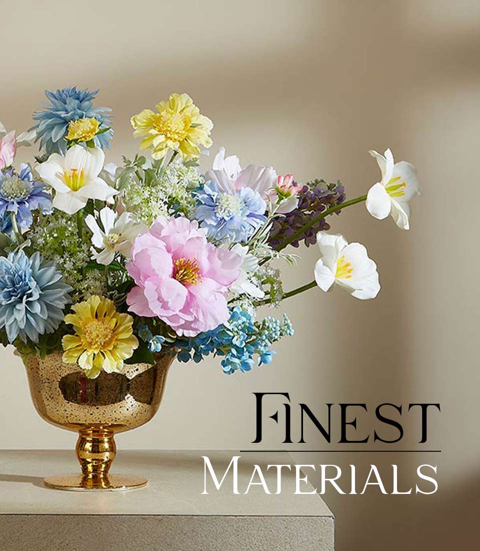 Vibrant springtime artificial flowers in soft blue, yellow, pink, and white arranged in a distressed gold goblet vase
