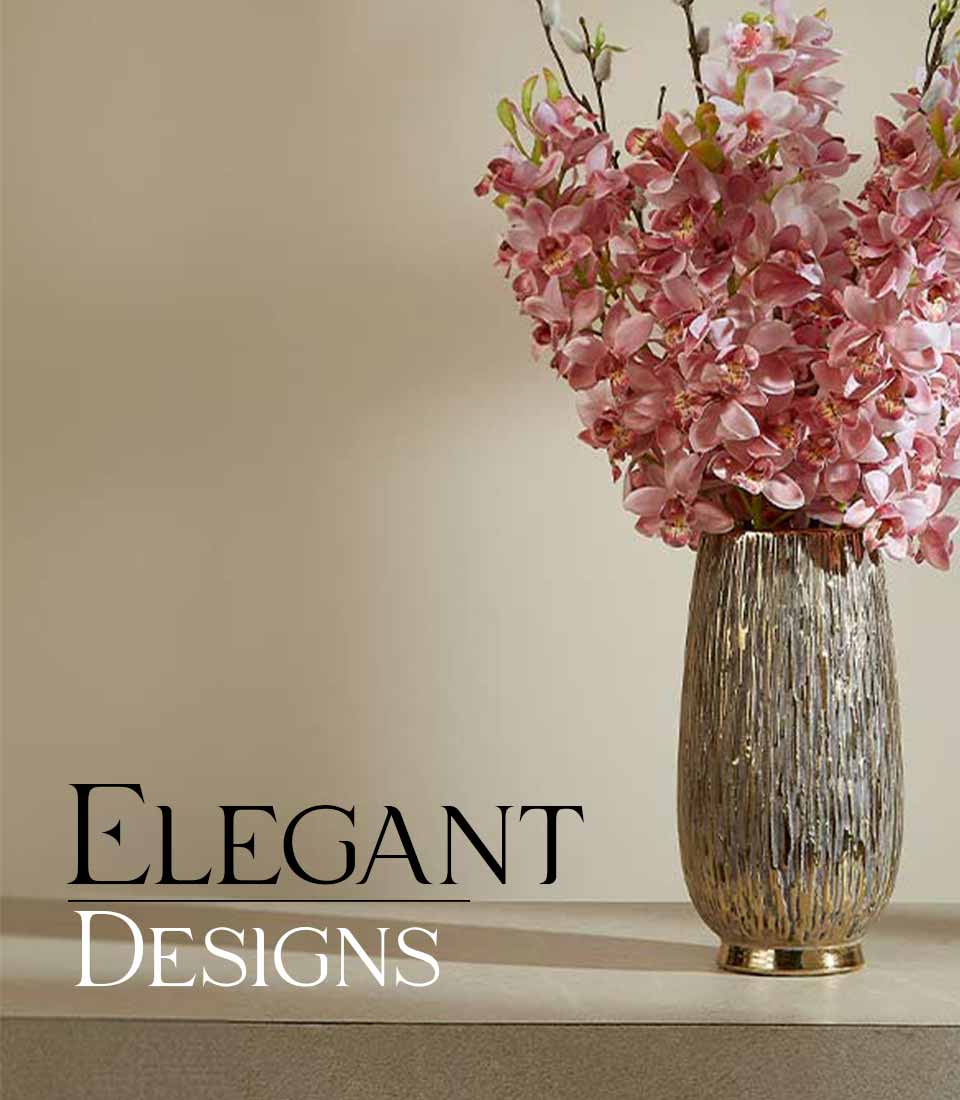 Pink orchid artificial flowers in metallic textured vase with greenery