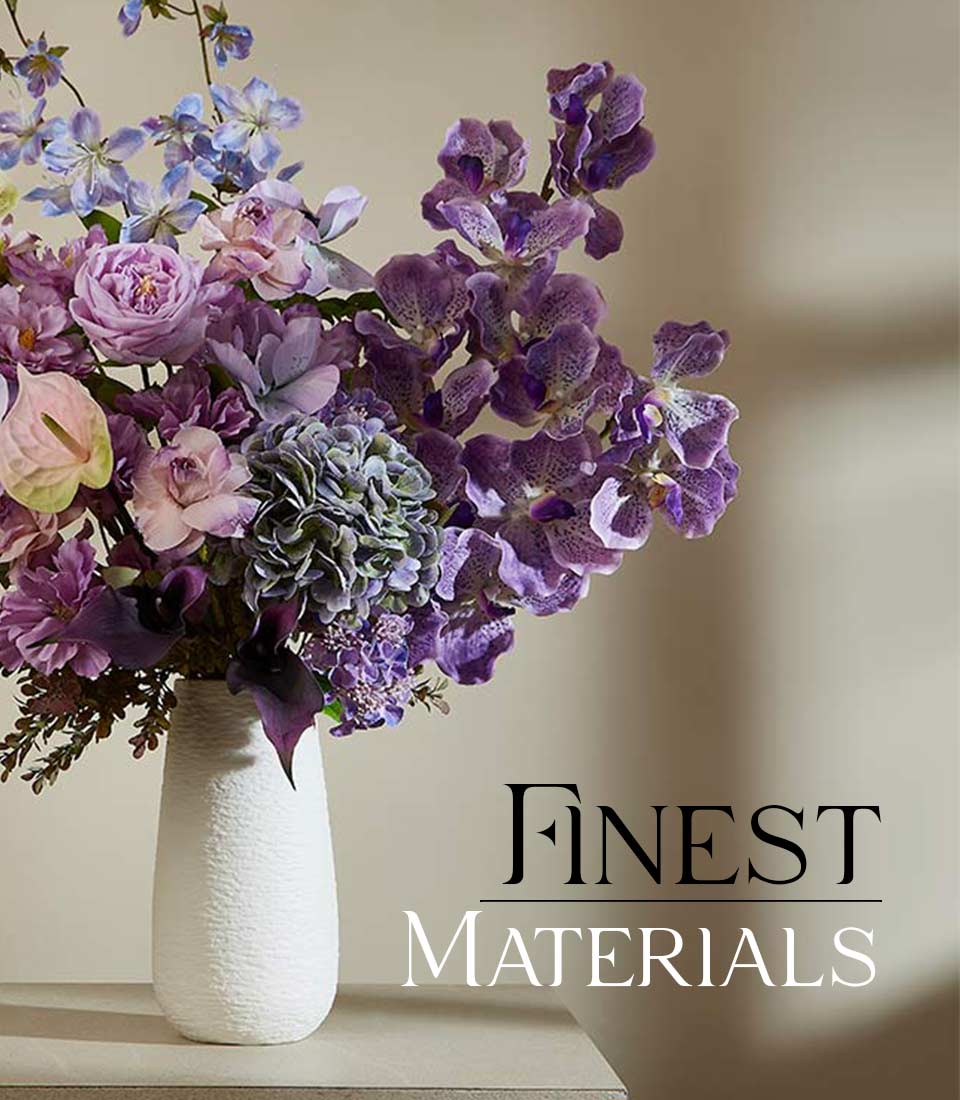 Purple and lavender artificial flower arrangement in white textured vase with orchids, roses, and hydrangeas