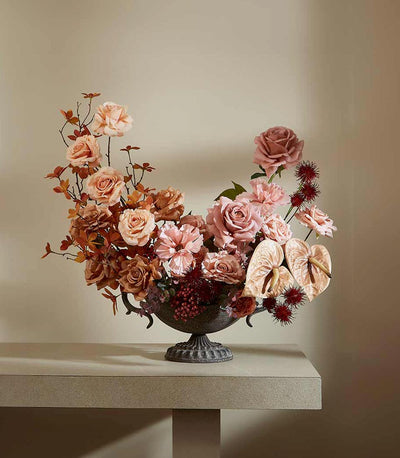 Autumn's Harvest Glow artificial flower arrangement in dark urn vase with peach roses, dusty rose carnations, and deep