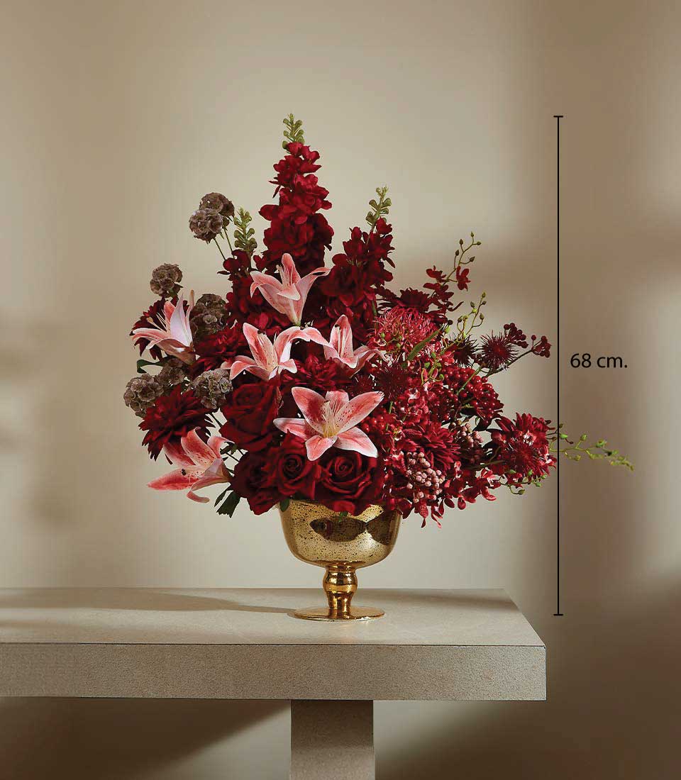 Crimson Bloom artificial flower arrangement with red roses, snapdragons, and pink lilies in gold pedestal vase