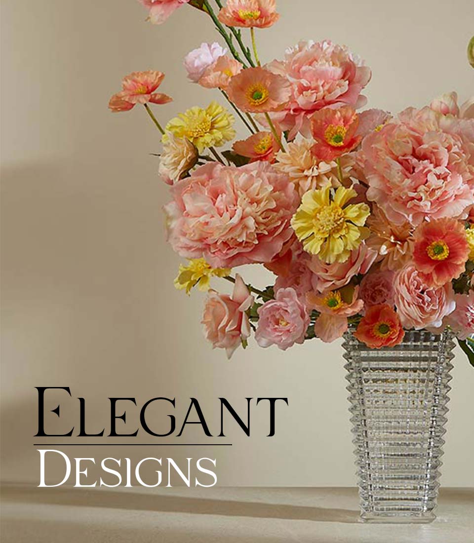 Vibrant pink, peach, and yellow artificial peonies and poppies in textured glass vase