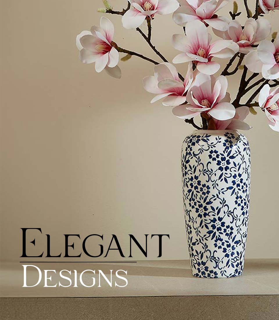 White ceramic vase with blue floral pattern filled with delicate pink and white artificial magnolia flowers