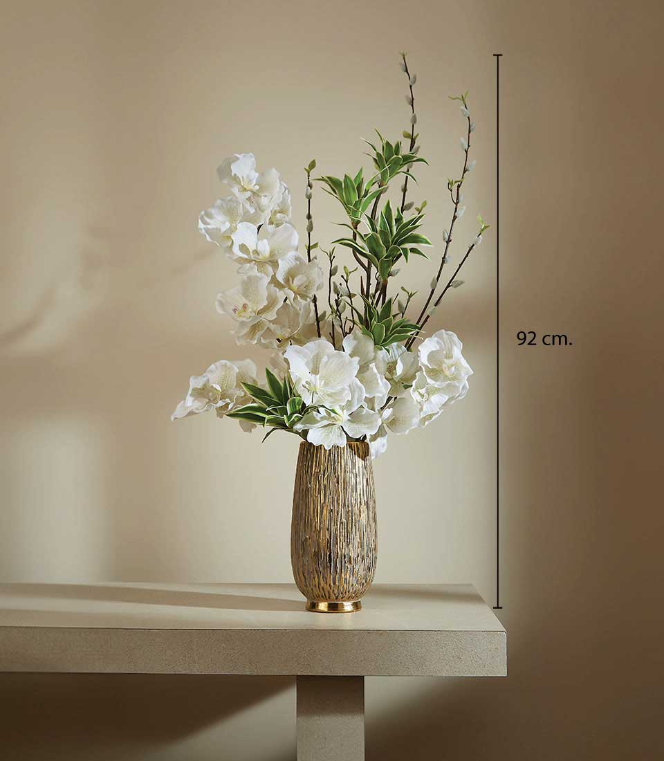 Tall cylindrical gold vase with white artificial orchids, green foliage, and brown branches, 92 cm height