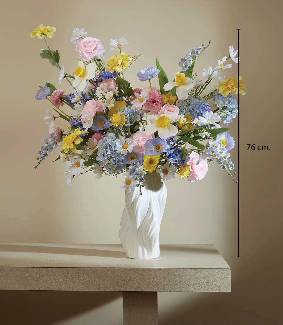 Vibrant spring bloom artificial flower arrangement in white ceramic vase with pink roses, hydrangeas, and mixed colorful