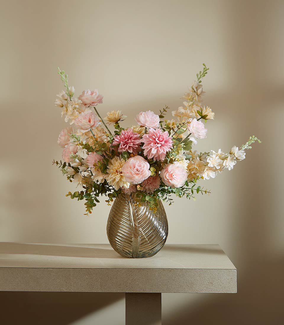 Premium artificial flower arrangement with pink dahlias, peonies, and eucalyptus in leaf-patterned glass vase