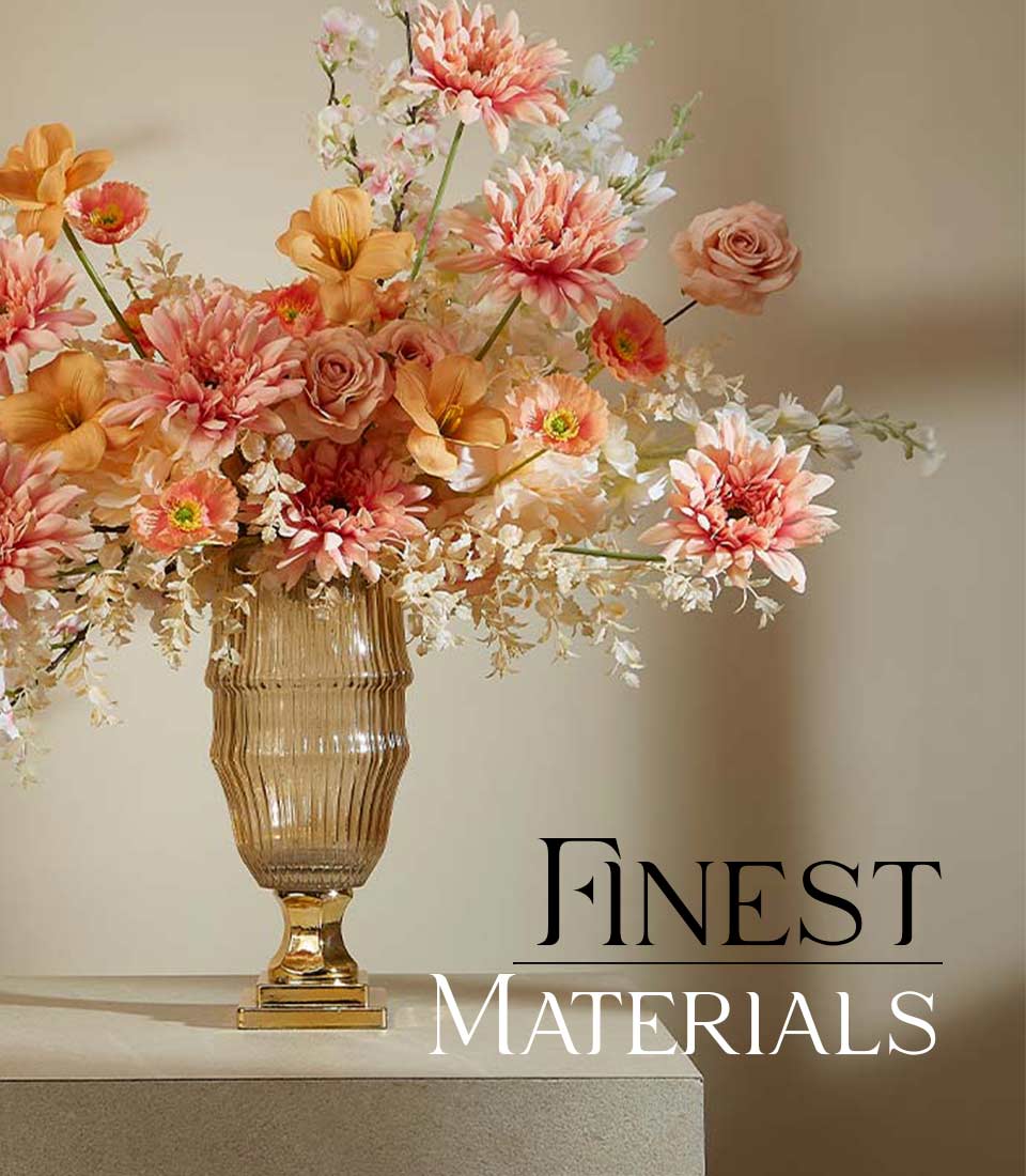 Peach and coral artificial flower arrangement with dahlias and roses in tall ribbed glass urn with gold base