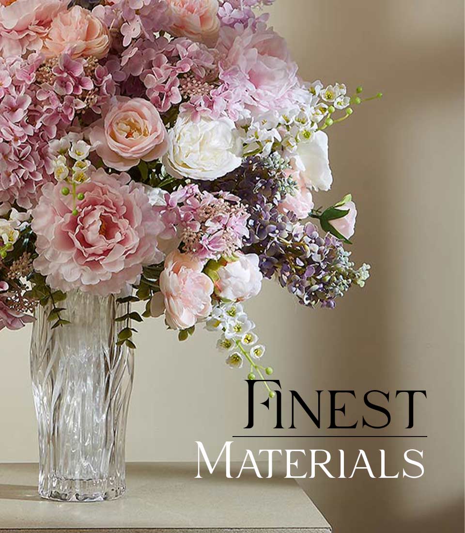Graceful luxury artificial flower arrangement with pink peonies, white roses, and purple accents in textured glass vase
