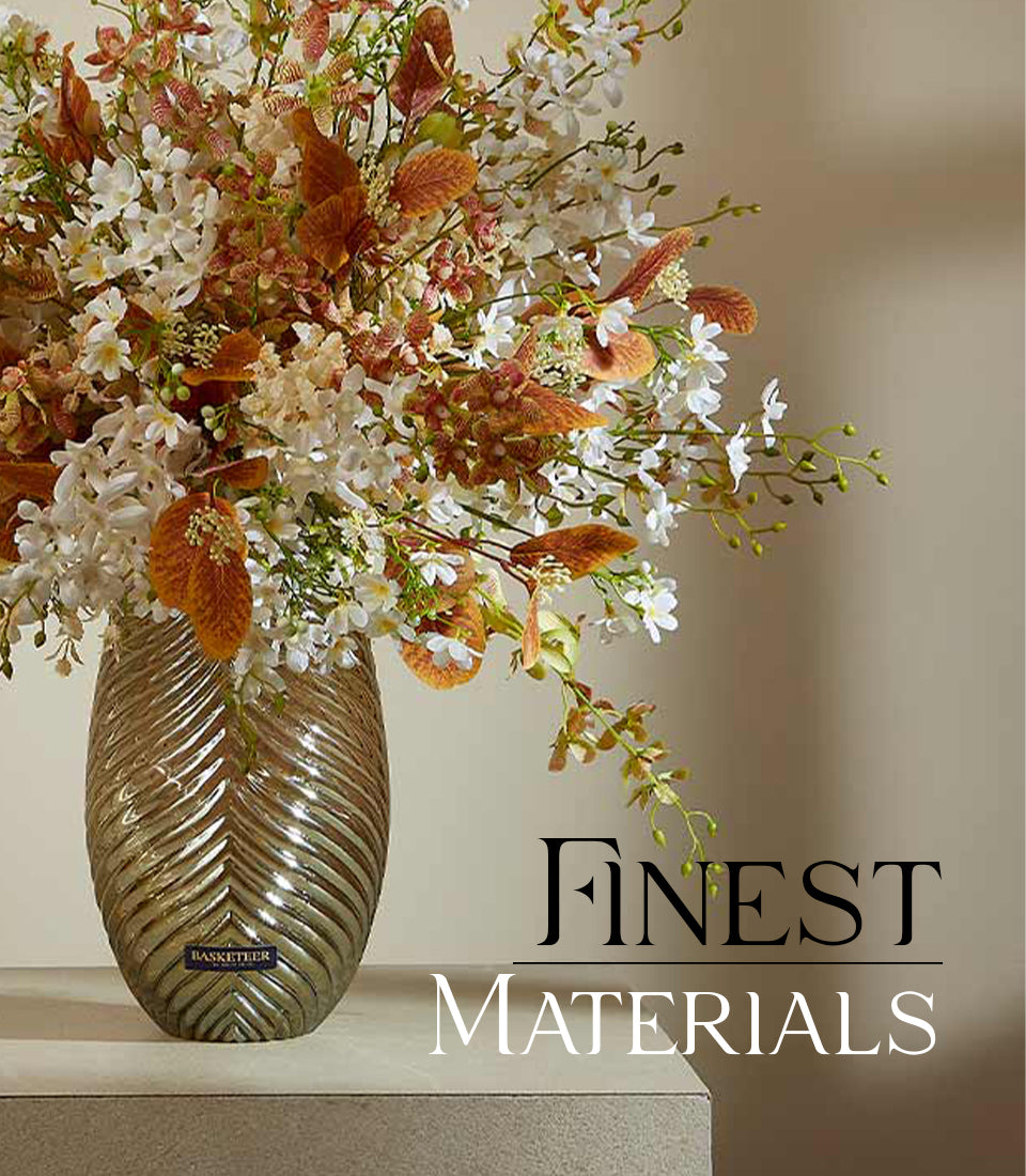Lush white and rust artificial flower arrangement in tall gold ribbed glass vase