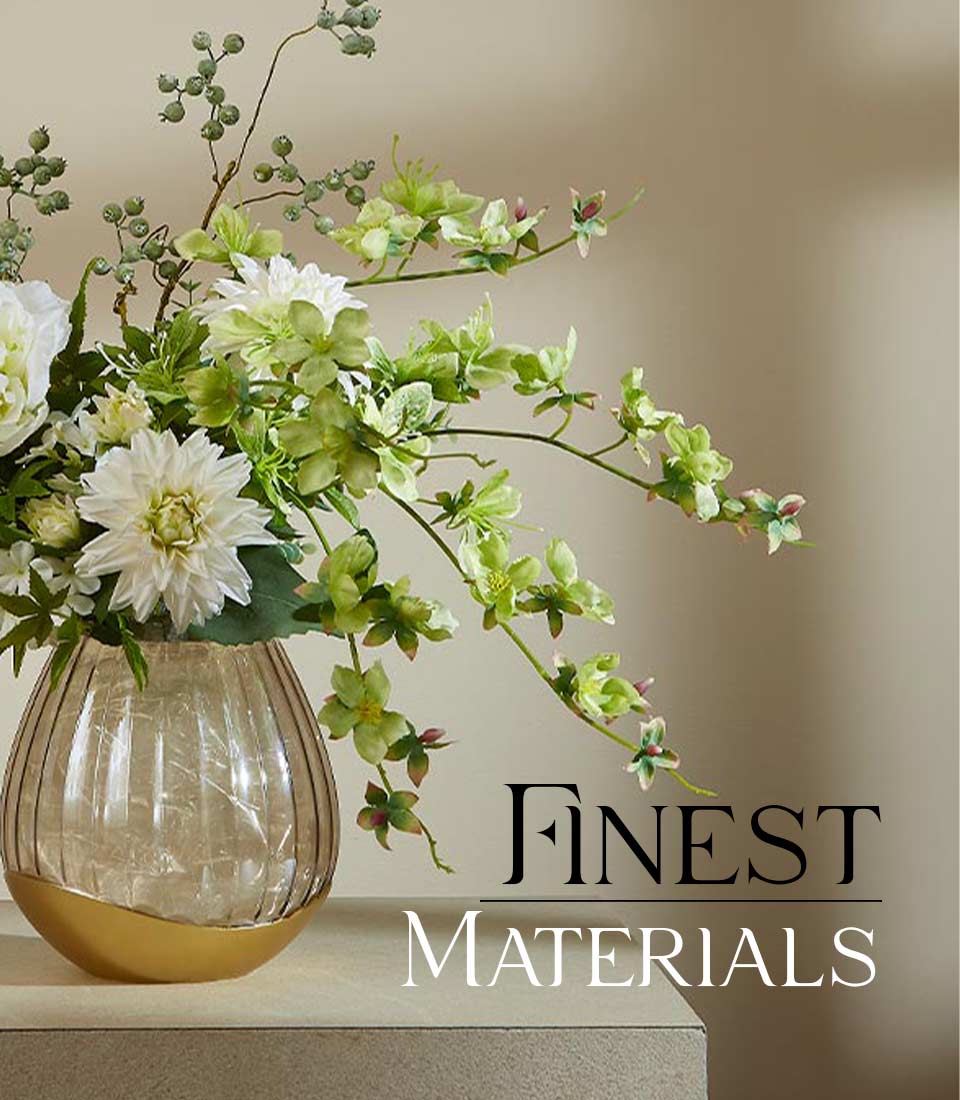 White and light green artificial dahlia arrangement in amber ribbed glass vase with gold base