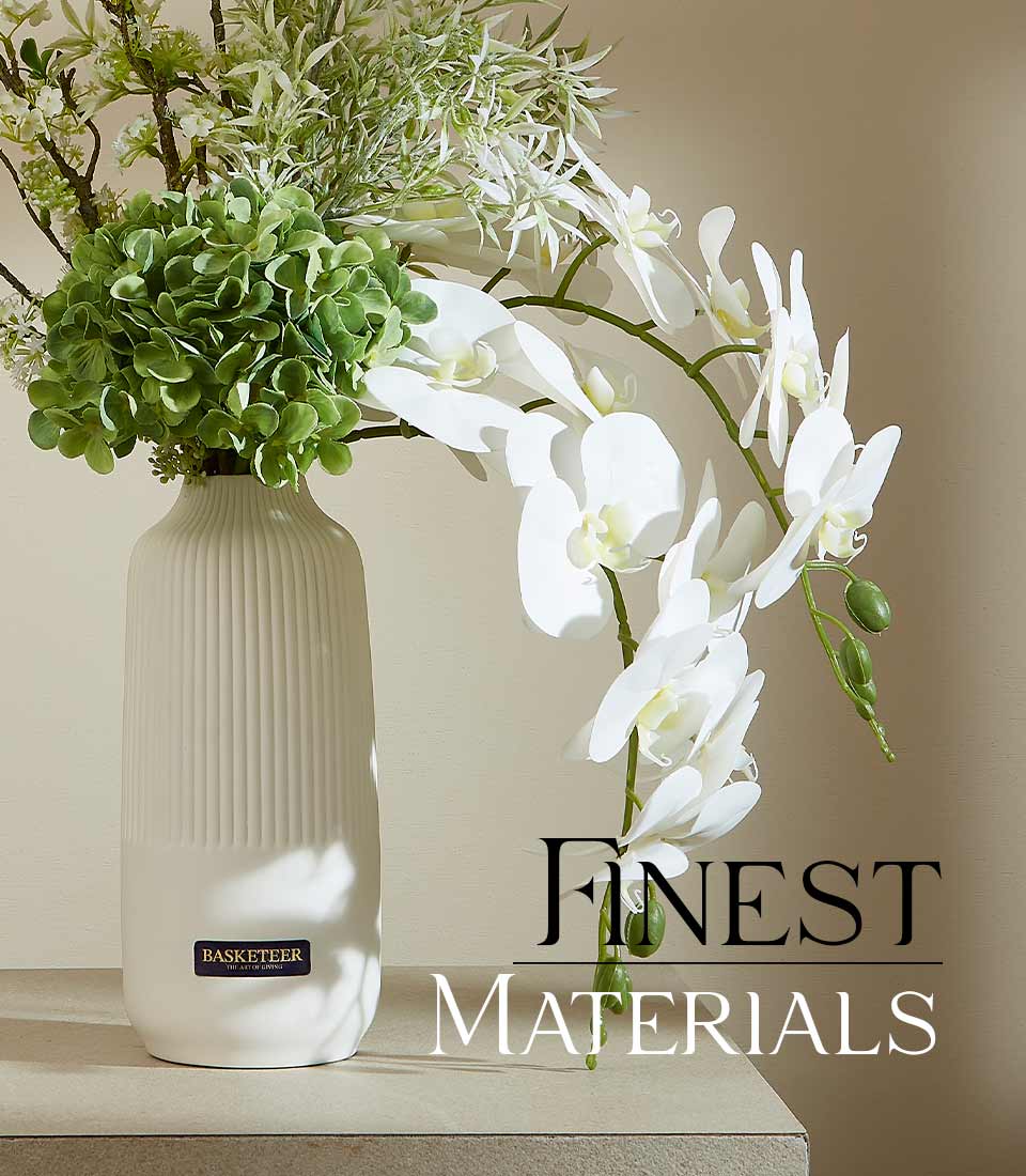 Cream ribbed ceramic vase with green hydrangea, white orchids, and delicate branches artificial flower arrangement