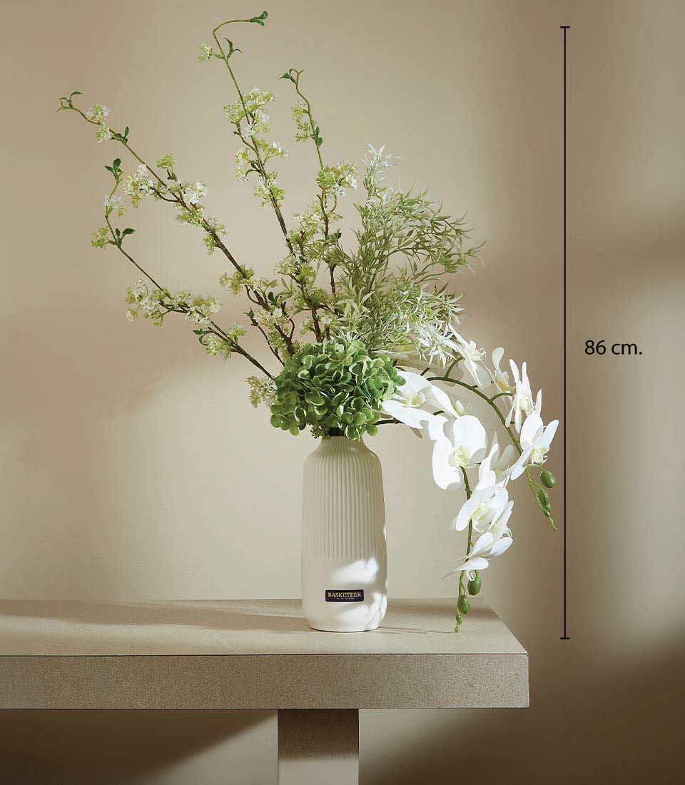 Tall white ceramic vase with artificial white orchids, hydrangeas, and green foliage, 86 cm height
