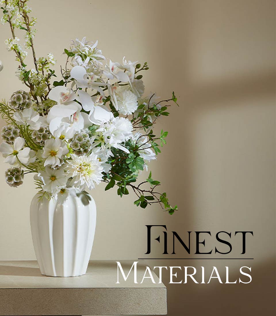 Frosty white orchid and dahlia artificial flower arrangement in ribbed ceramic vase with greenery