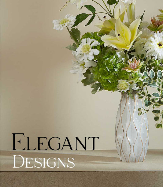 White and yellow lilies with daisies and green hydrangeas in elegant wavy gold glass vase