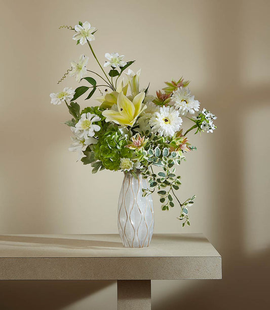 Serene Meadow artificial flower arrangement with yellow lilies, white daisies, and green hydrangeas in white textured vase