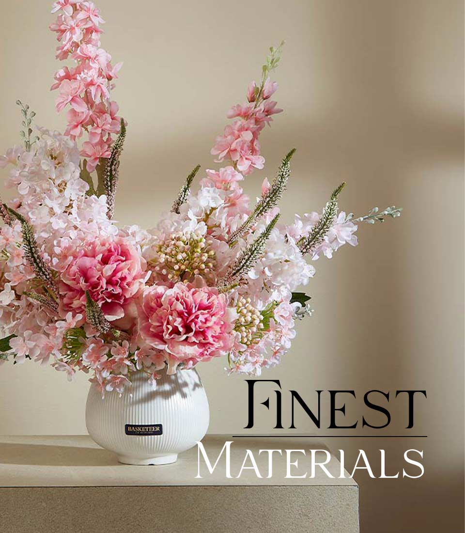Pink and white peony artificial flower arrangement in white ribbed ceramic vase with green foliage