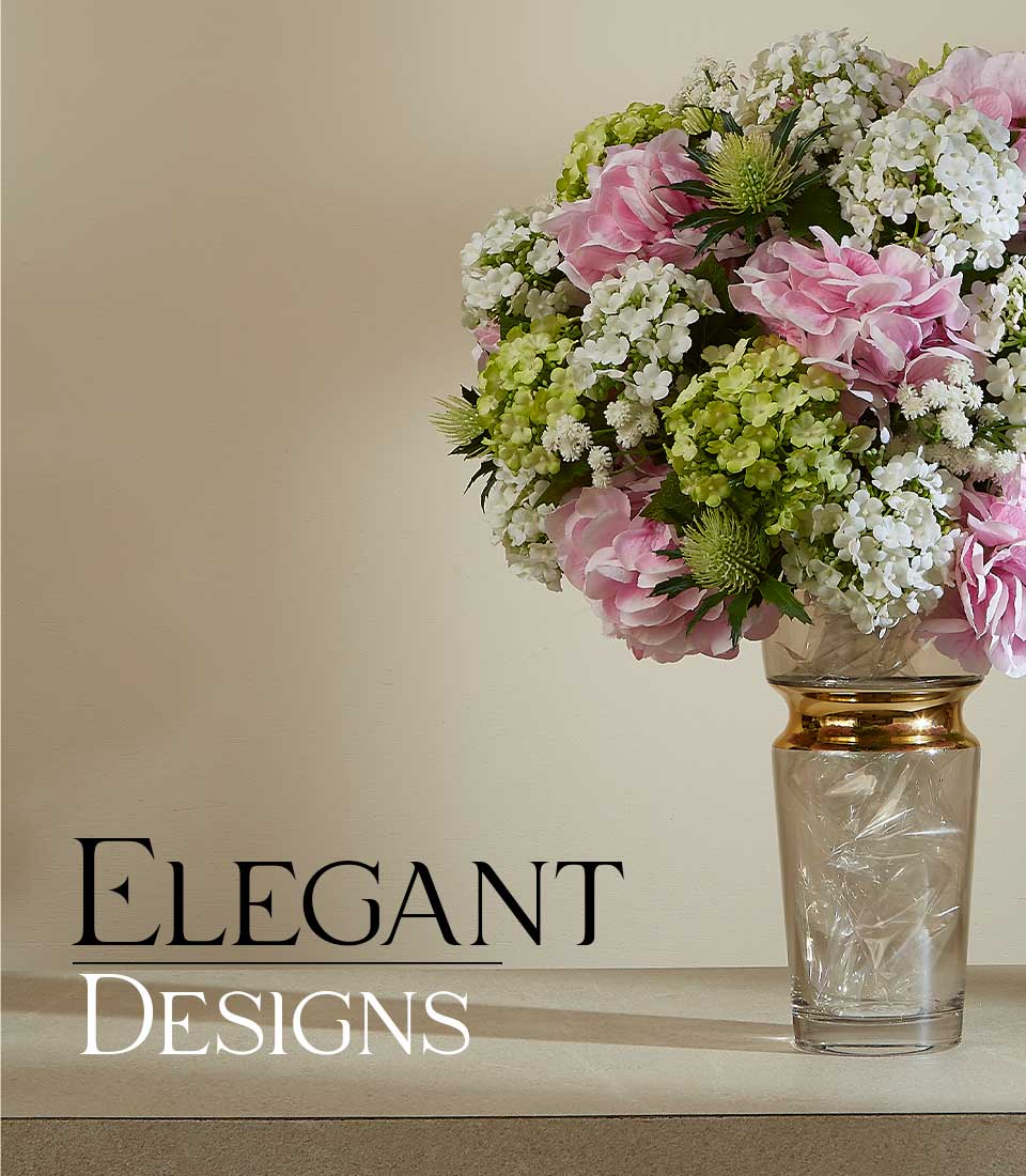 Pink peony and white flower arrangement in gold-trimmed glass vase with green hydrangeas