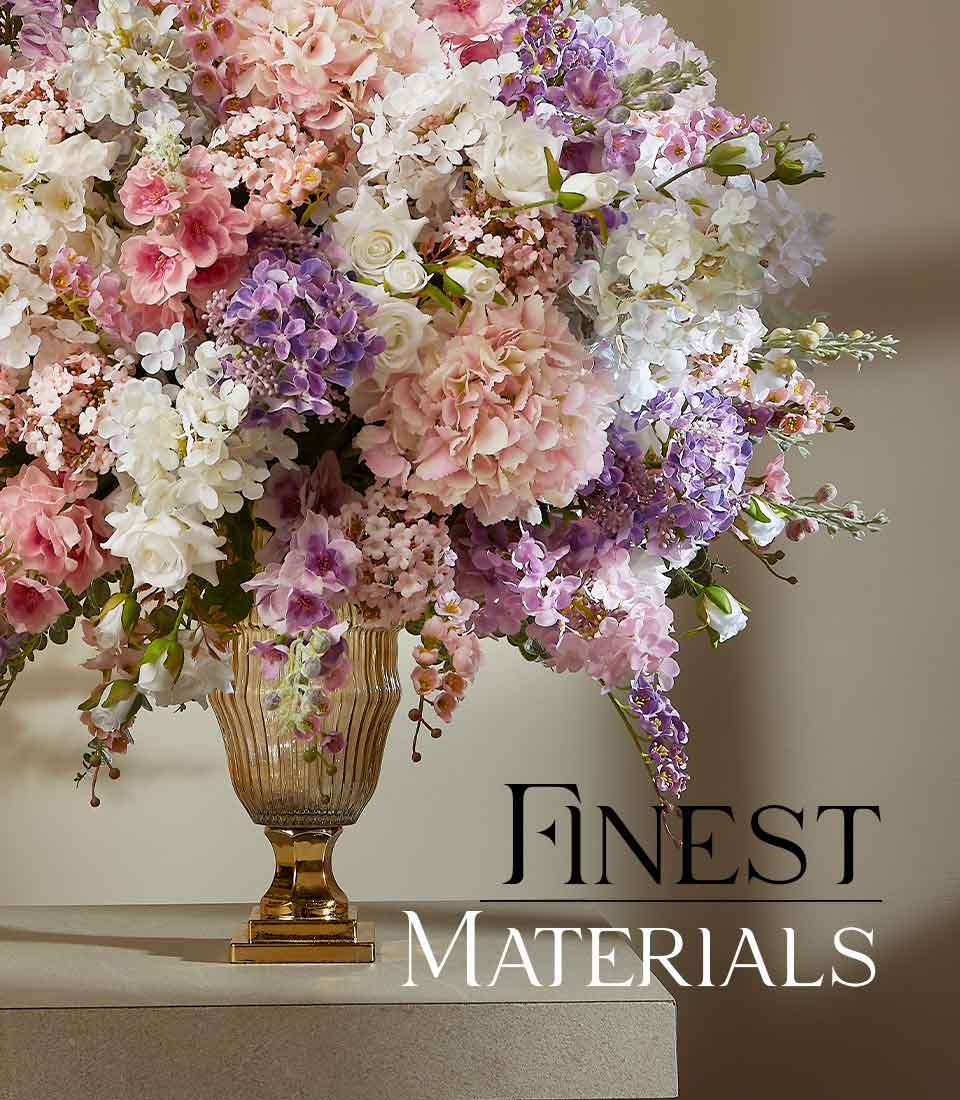Large artificial flower arrangement in pink, white, and purple hydrangeas and roses in golden glass urn vase