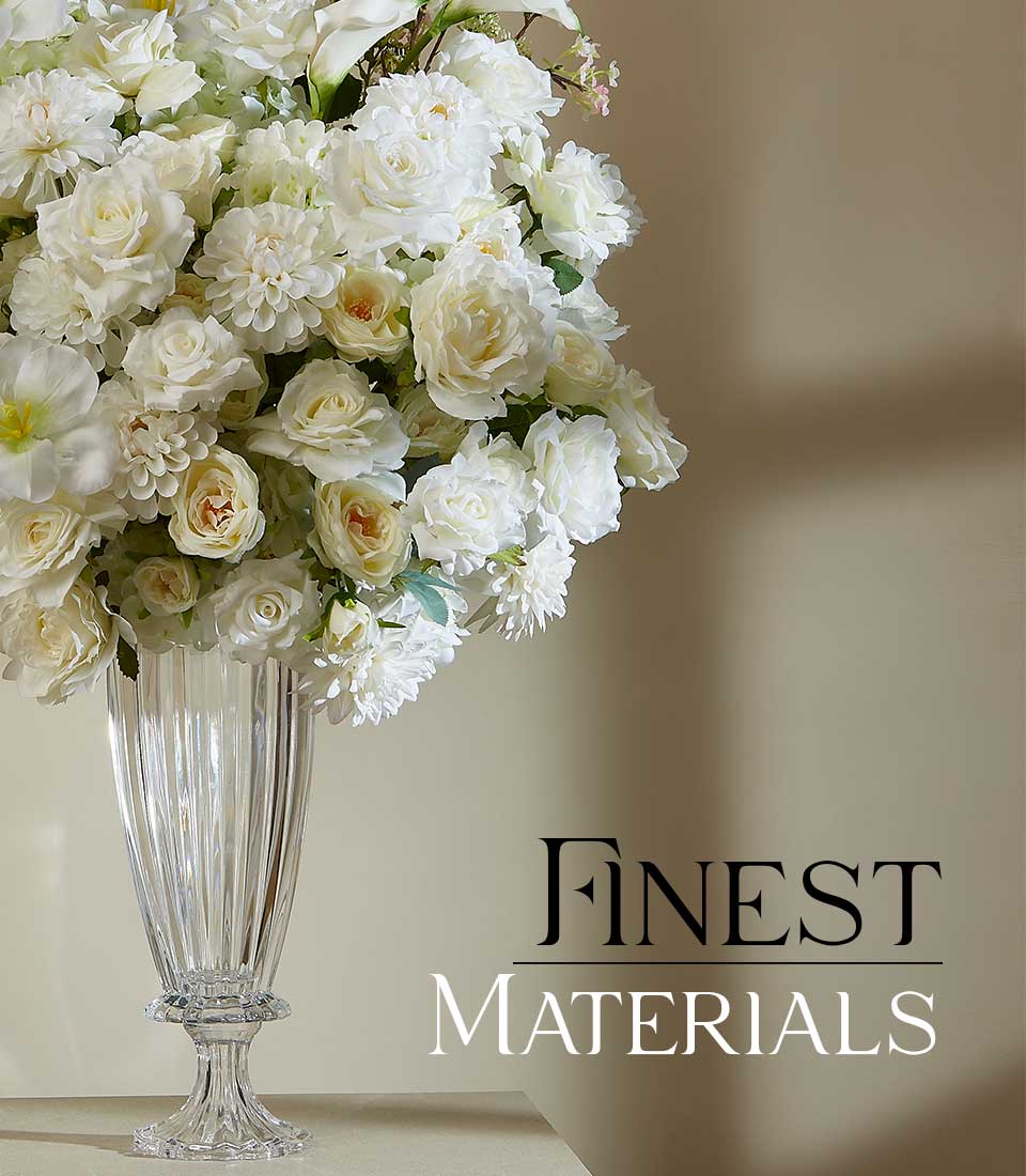 White and cream artificial rose and dahlia arrangement in ribbed glass pedestal vase