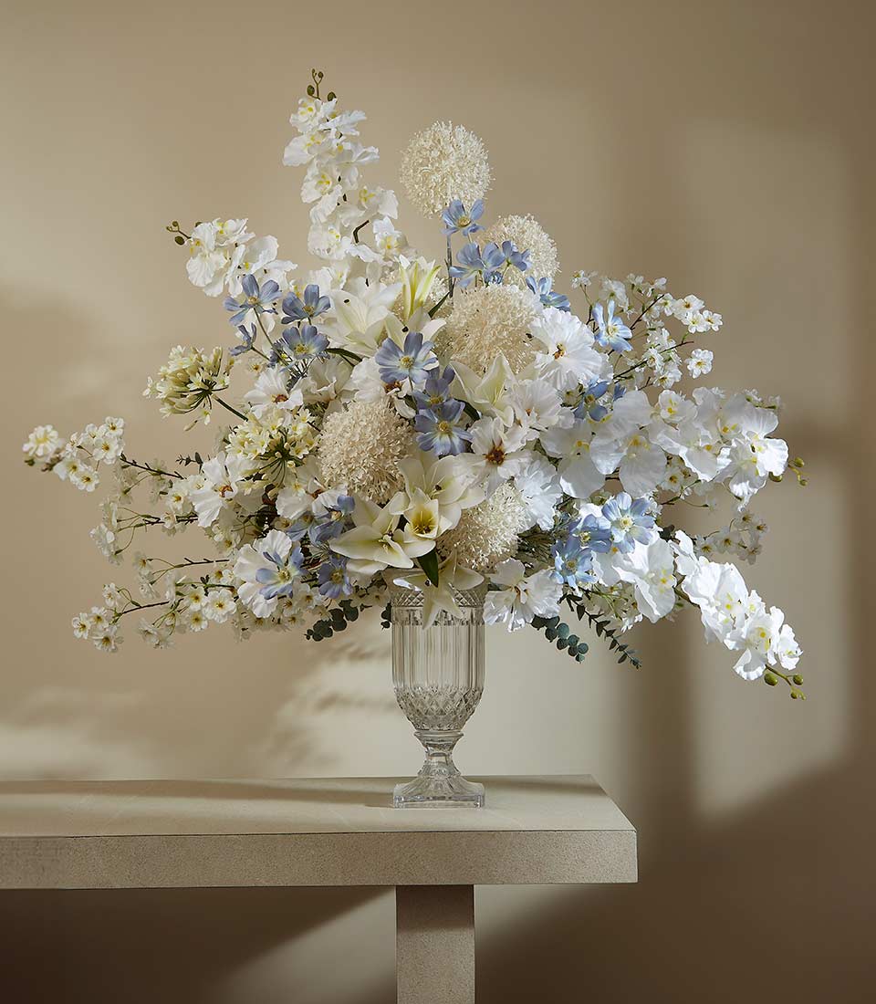 Ethereal white and cream artificial flower arrangement with orchids and lilies in square cut-glass vase