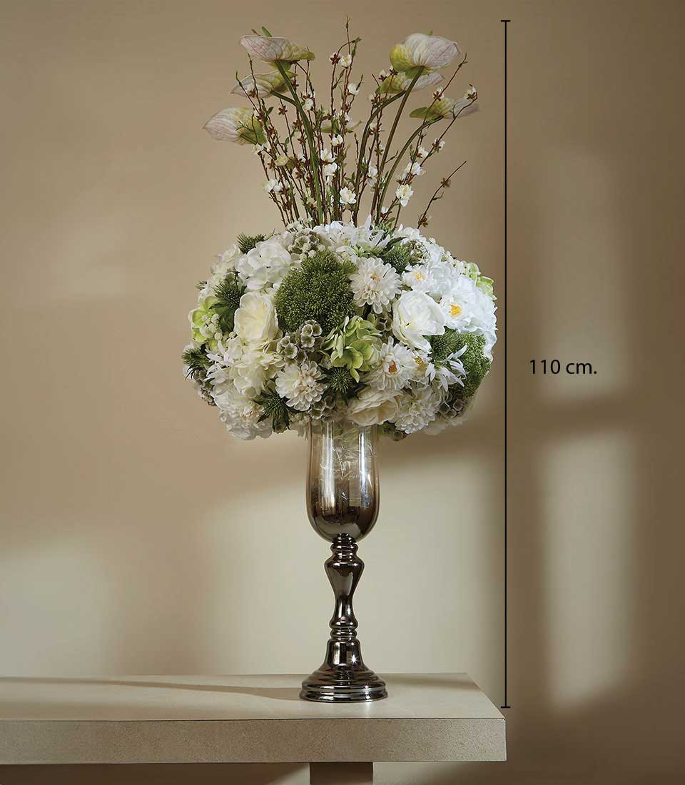 Tall artificial floral arrangement with white dahlias, hydrangeas, and pale pink blossoms in dark metallic vase
