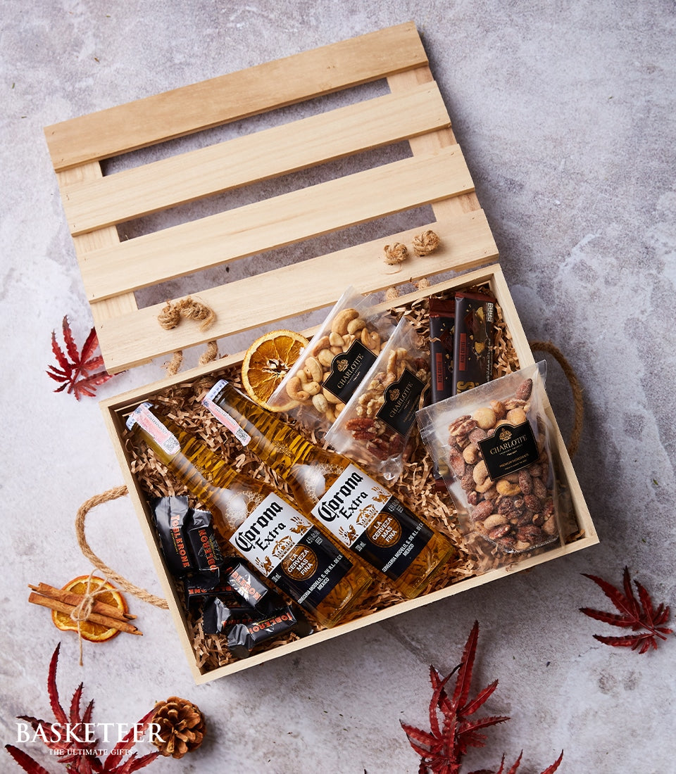 Corona Extra beer crate with chocolate, nuts, and dried fruit on shredded paper filler