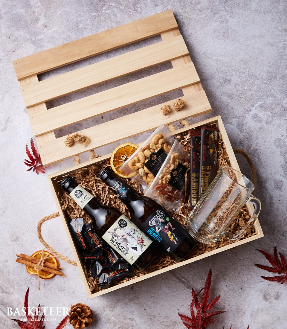 Artisan Thai beer hamper with craft beers, chocolates, nuts, and mug in wooden crate